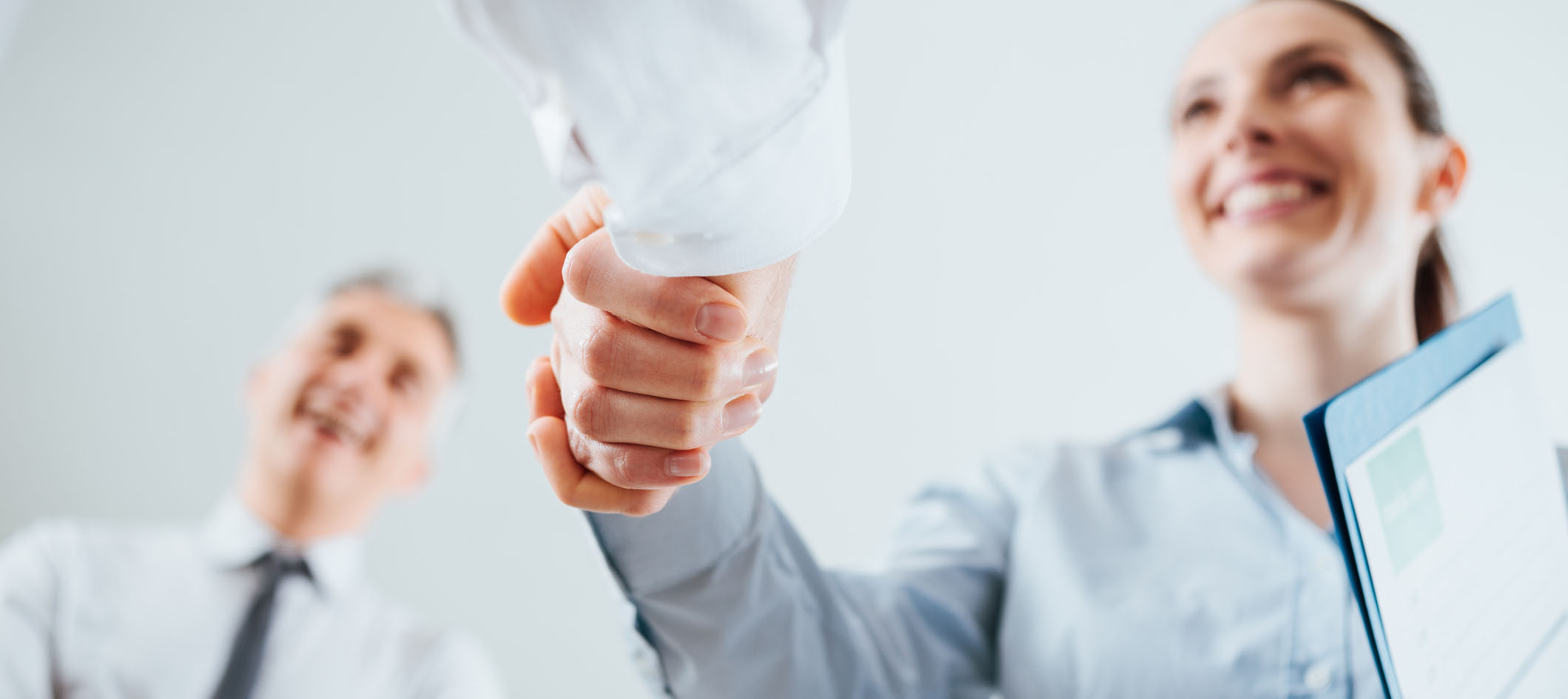 Pessoas dando as mãos durante entrevista de emprego