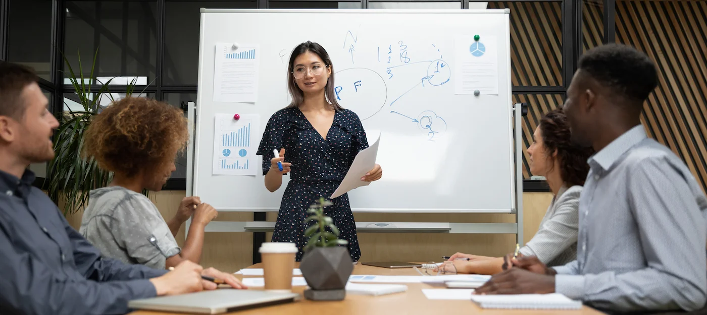 Mulher conduzindo treinamento na empresa, capa do conteúdo sobre tipos de treinamento e desenvolvimento