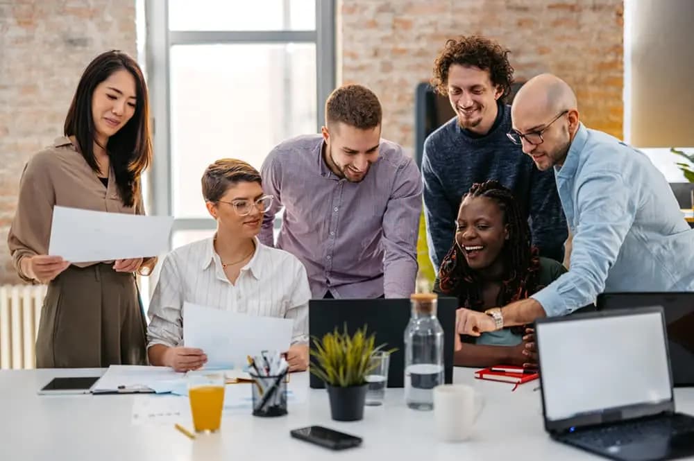 Equipe reunida discutindo documentos e analisando dados em ambiente de trabalho colaborativo — capa do conteúdo sobre tipos de perfil comportamental